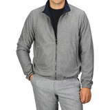 A person is wearing a Manto Navy Grey Cashmere Nylon Reversible Blouson over a black shirt and matching grey pants, with their left hand in the pocket.