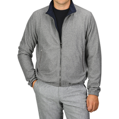 A person is wearing a Manto Navy Grey Cashmere Nylon Reversible Blouson over a black shirt and matching grey pants, with their left hand in the pocket.