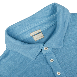 Close-up of a light blue Massimo Alba Aqua Blue Linen Polo Shirt collar with a tag and buttons.