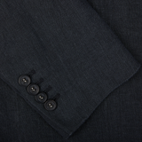 Four black buttons on a dark fabric of an Massimo Alba Black Washed Linen Unstructured Blazer, possibly a sleeve detail of the garment.