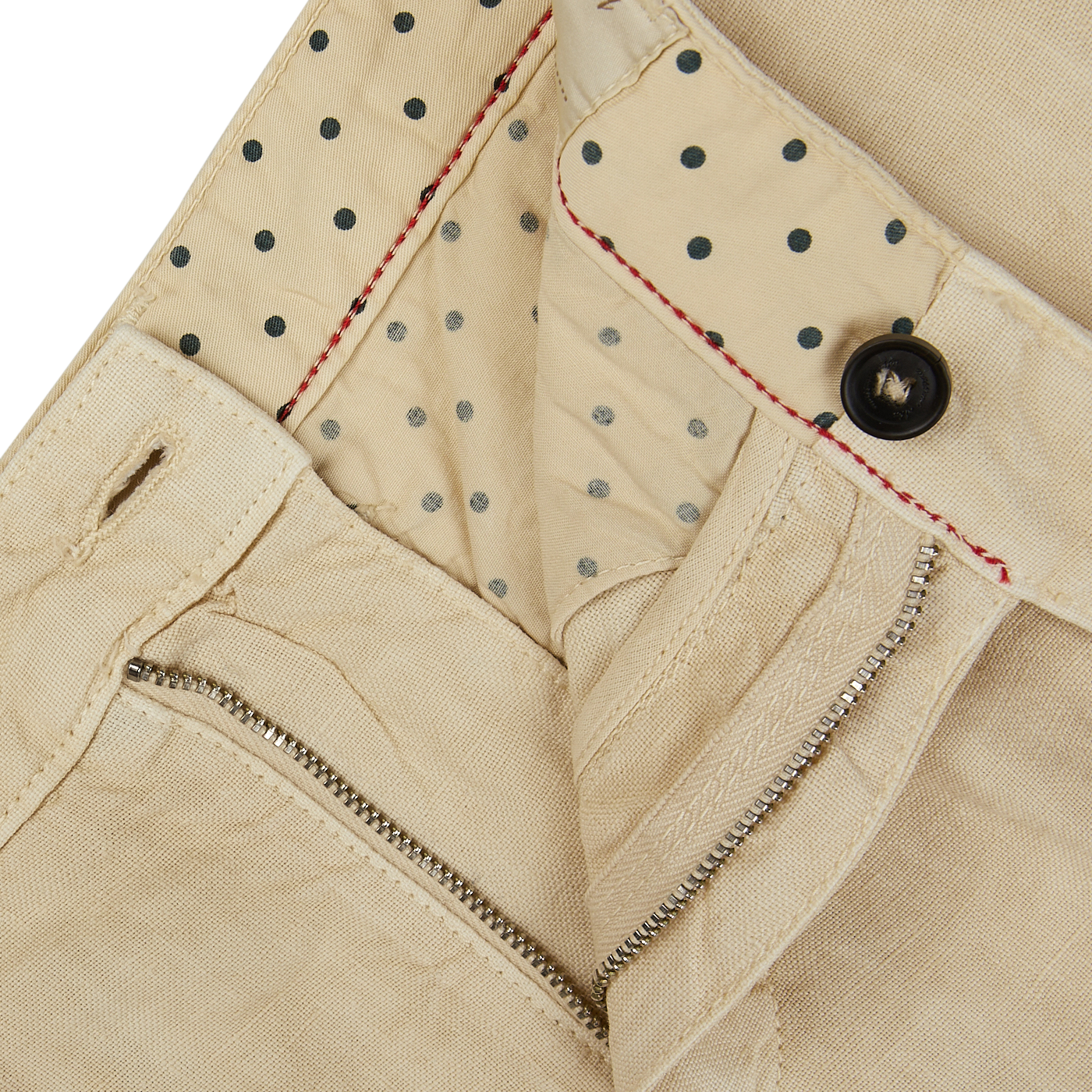 Close-up of a light beige linen garment with a dotted lining, featuring a zipper and button closure with red stitching detail on Massimo Alba casual trousers.