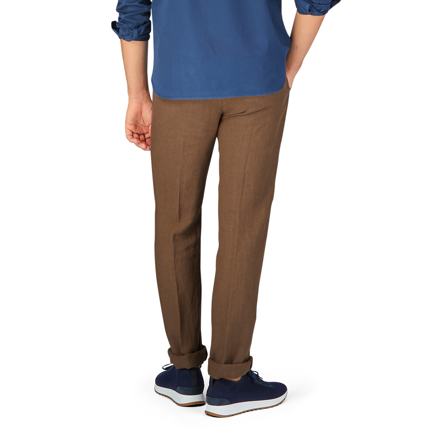 Man standing sideways wearing Massimo Alba Light Brown Linen Casual Trousers made in Italy, a blue shirt, and blue sneakers.