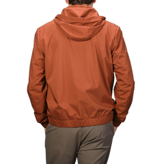 The individual is seen from the back wearing a Terracotta Brown Nylon Hooded Blouson Jacket by Maurizio Baldassari with khaki pants.