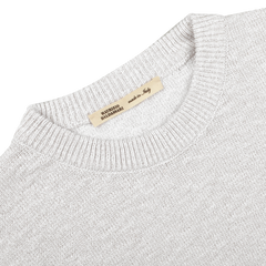 Close-up of a Maurizio Baldassari Cream Summer Mouline Crew Neck Sweater, in light gray cotton-viscose blend with a textured pattern and visible "Made in Italy" tag.