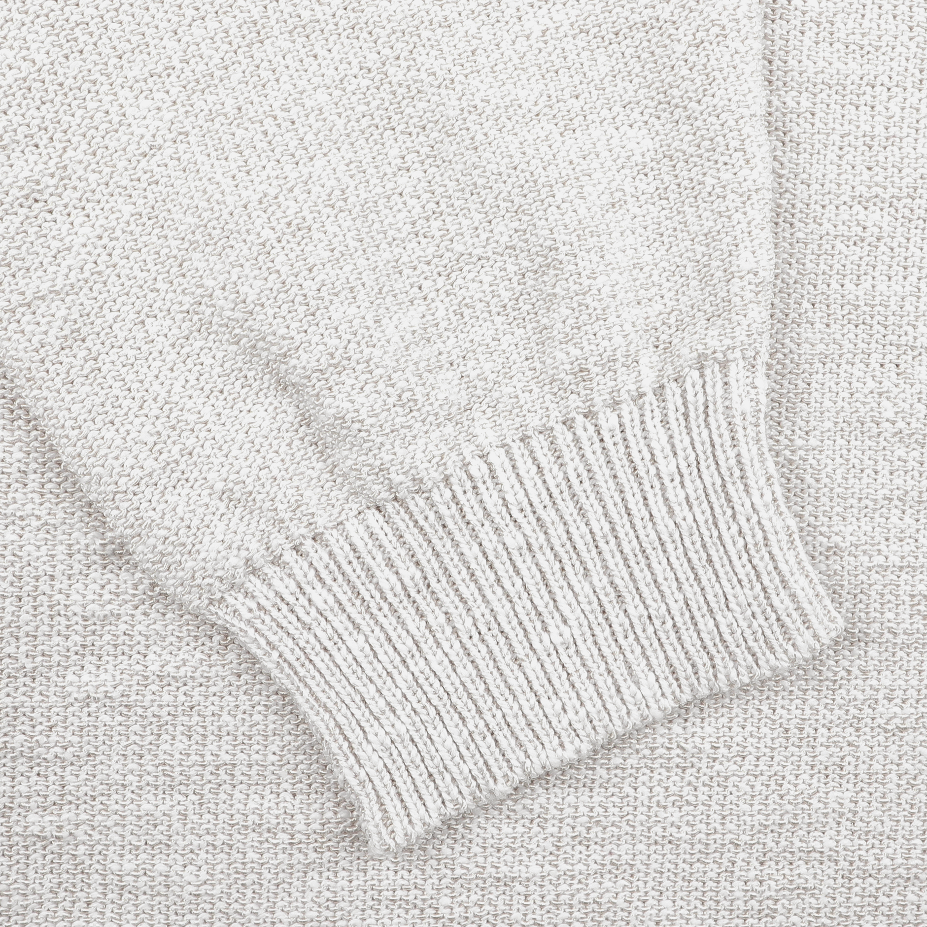 Close-up of a cream cotton-viscose blend knit fabric from the Maurizio Baldassari Summer Mouline Crew Neck Sweater, highlighting the ribbed cuff and texture details.