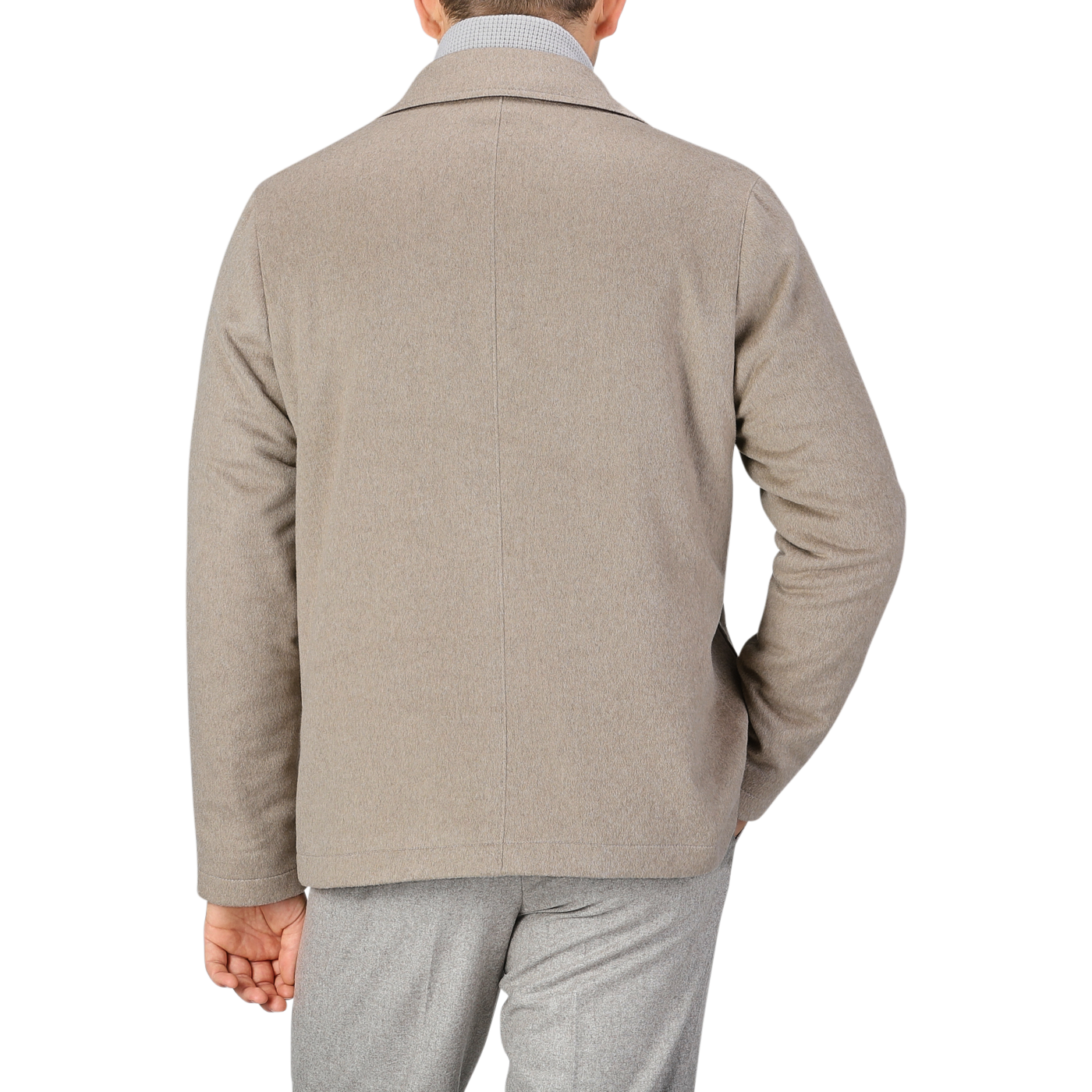 A person is shown from the back wearing a beige cashmere half padded chore coat by Maurizio Baldassari and grey pants against a plain background.