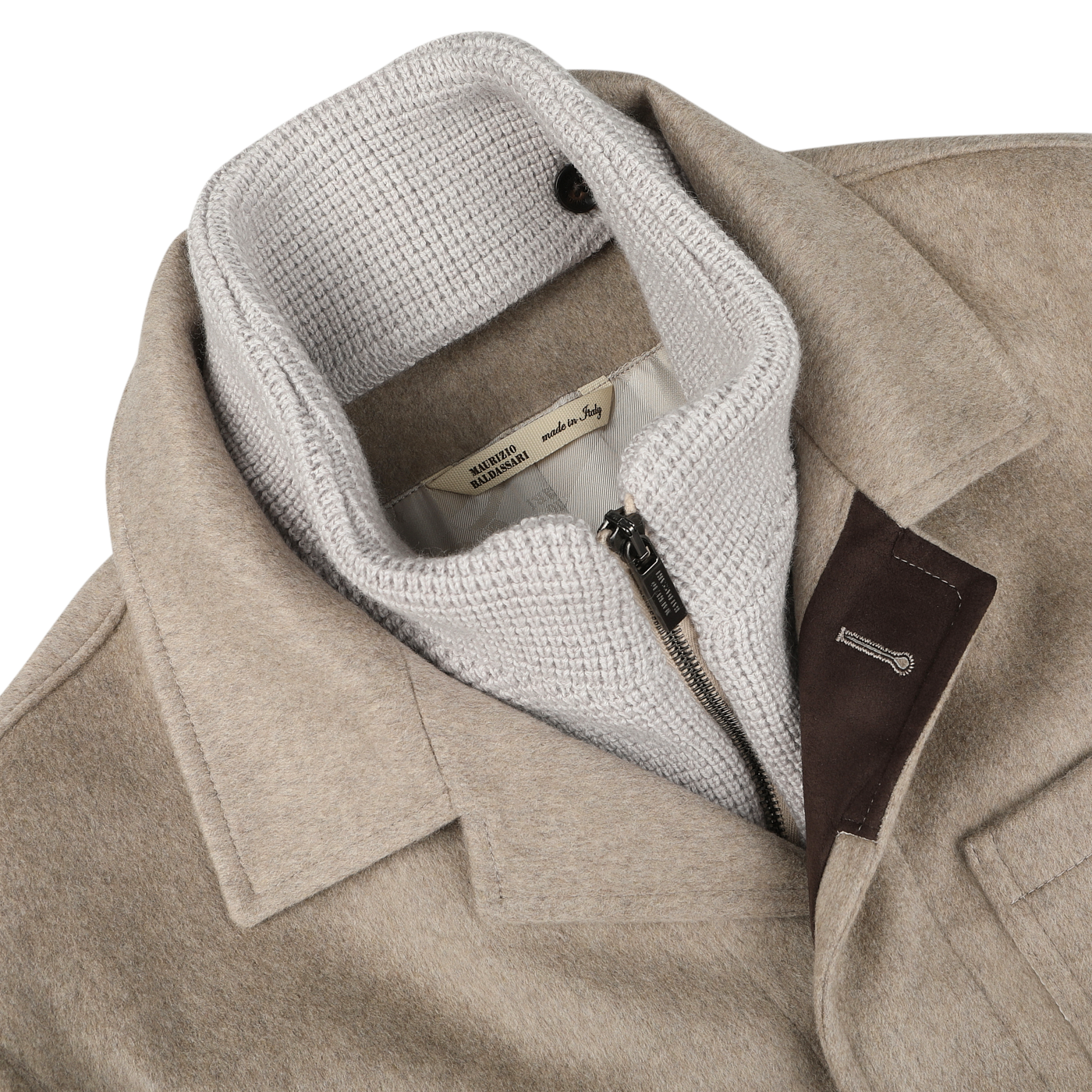 The Beige Cashmere Half Padded Chore Coat by Maurizio Baldassari features a white knitted inner lining and black zipper detail. It boasts a fabric label that reads "made in Italy," an outer pocket with a leather accent, and includes a detachable wool-cashmere waistcoat for versatile wear.