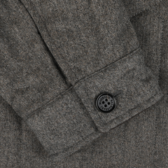 Close-up of the sleeve of a Taupe Beige Herringbone Quilted Virgin Wool Overshirt by Maurizio Baldassari, showcasing a buttoned cuff with a four-hole black button.