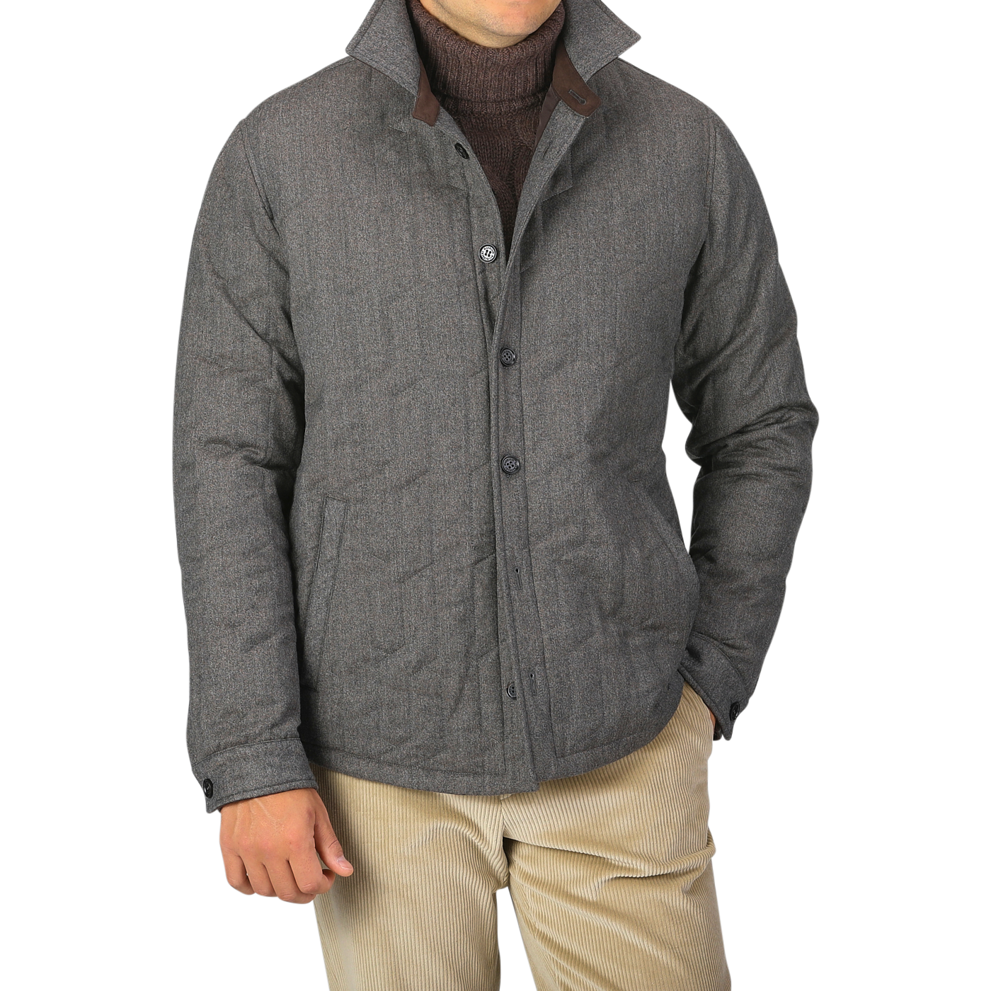 A person wearing a Maurizio Baldassari Taupe Beige Herringbone Quilted Virgin Wool Overshirt over a dark sweater and light-colored pants, with their hands partially in their pockets.