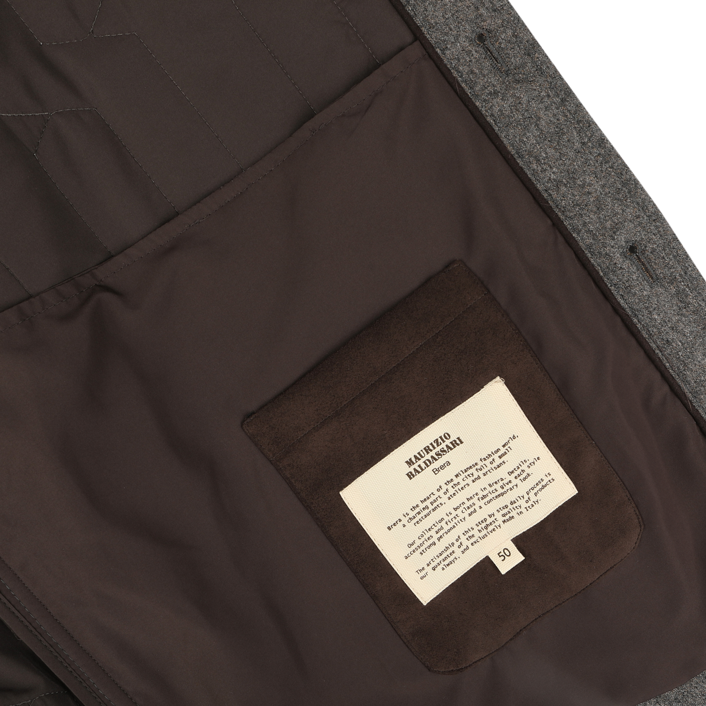 The image shows the inside of a Taupe Beige Herringbone Quilted Virgin Wool Overshirt by Maurizio Baldassari, featuring a brown interior made from virgin wool. A beige label with text is sewn onto a brown pocket on the left side.