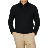 Man wearing a Black Cotton Silk Cable-Knit 1/4 Zip Sweater by Maurizio Baldassari and beige pants.
