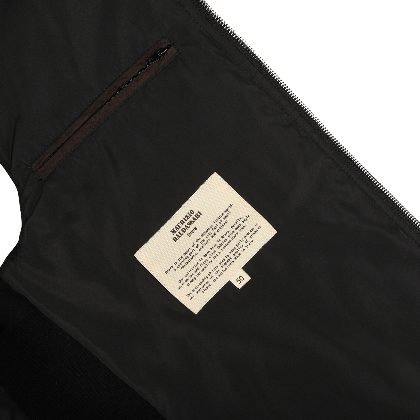 Close-up of the interior of the Maurizio Baldassari Black Water Repellent Cashmere Gilet, showcasing a cream label with text and a small pocket above it. The label provides maintenance or design details, hinting at the luxurious cashmere craftsmanship typical of the brand.