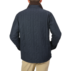 A person wearing a blue melange quilted virgin wool overshirt by Maurizio Baldassari, khaki pants, and a dark collar is seen from the back.