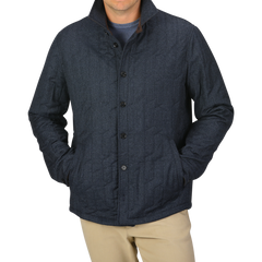 A person wearing the Blue Melange Quilted Virgin Wool Overshirt by Maurizio Baldassari with their hands in the pockets. The background is plain light gray.