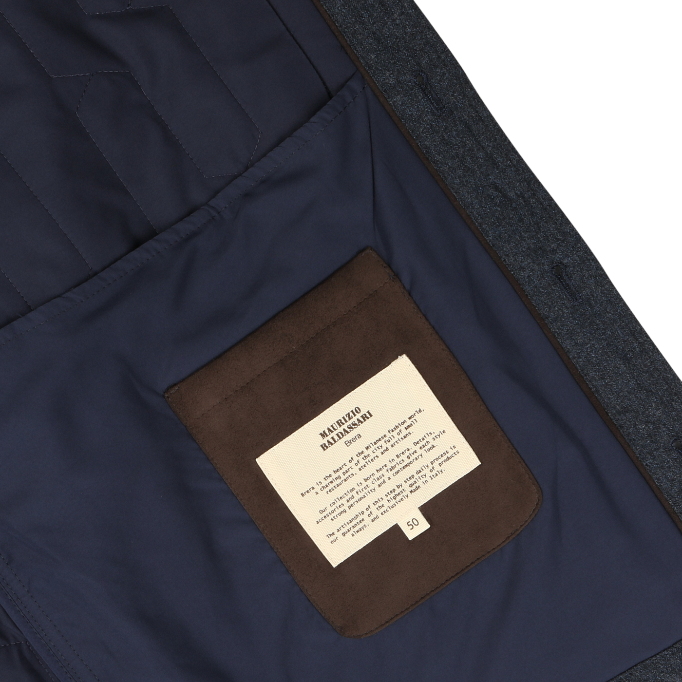 Close-up of the inside of a Blue Melange Quilted Virgin Wool Overshirt with a brown pocket. A white label with text is sewn onto the pocket. The overshirt, designed by Maurizio Baldassari, appears to be neatly lined and well-tailored.