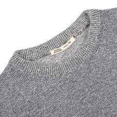 The Blue Melange Summer Mouline Crew Neck Sweater by Maurizio Baldassari is crafted from a luxurious cotton-viscose blend, featuring a visible woven texture enhanced by a subtle summer mouline knit, with a white label on the collar displaying text.