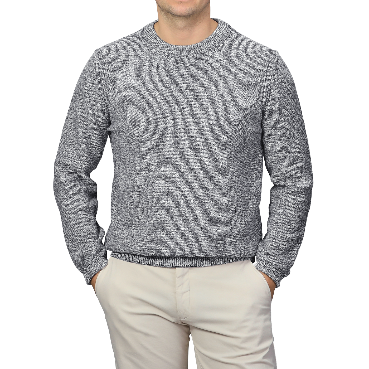 A person wearing a Blue Melange Summer Mouline Crew Neck Sweater by Maurizio Baldassari and beige pants stands with hands in pockets against a plain background.