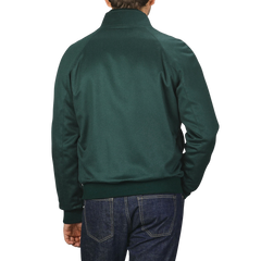 A person is shown from the back wearing a Maurizio Baldassari Bottle Green Cashmere Zip Blouson and blue jeans against a plain background.