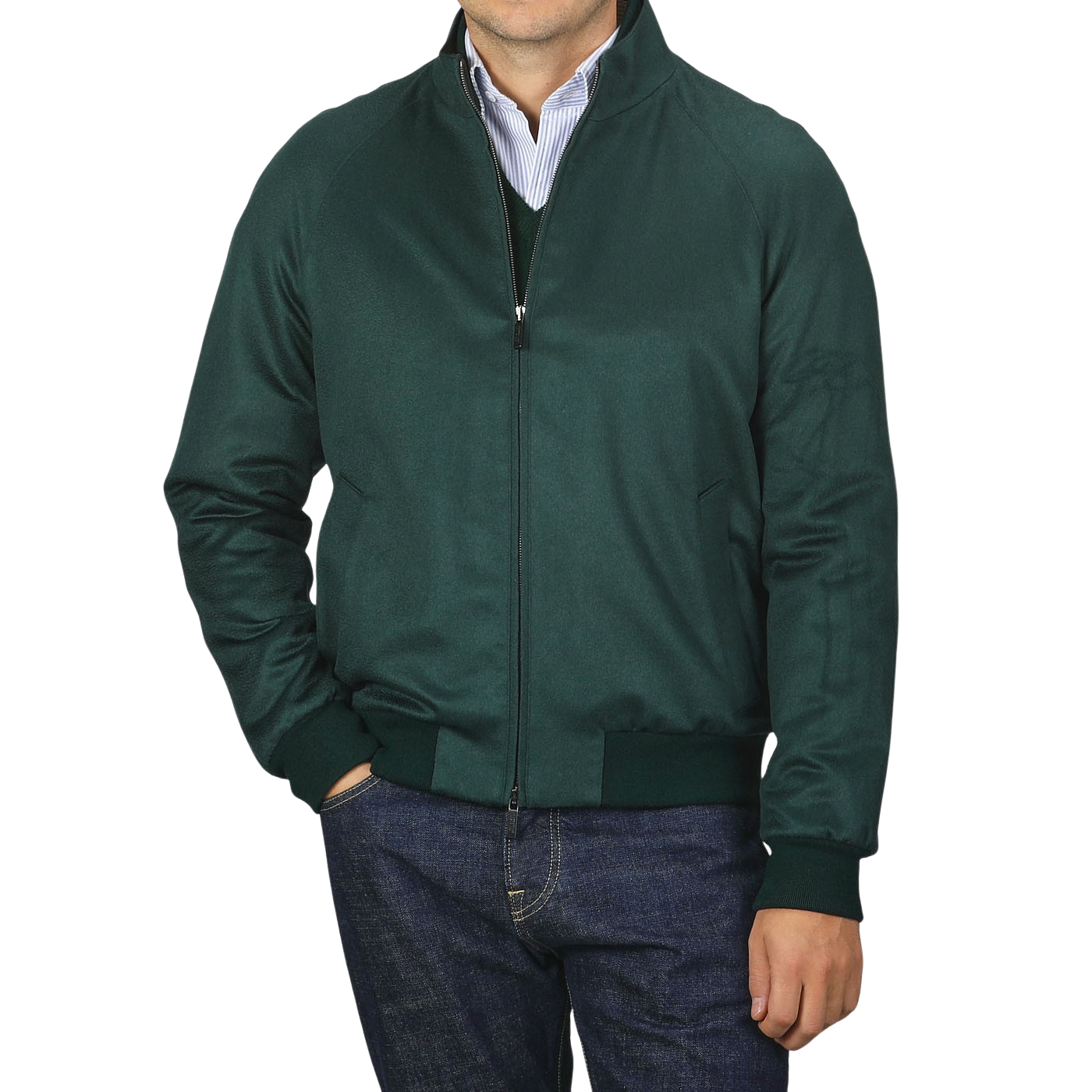 A person wearing a Maurizio Baldassari Bottle Green Cashmere Zip Blouson over a blue and white striped shirt and jeans. The person's hands are in the jacket pockets, and the jacket collar is slightly raised.