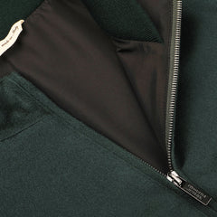 Close-up image of the Bottle Green Cashmere Zip Blouson by Maurizio Baldassari, showcasing a partially open metallic zipper and an interior label with "made in Italy" text.