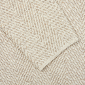 A close up of a white towel with a Brown Herringbone Silk Cotton Linen Swacket pattern by Maurizio Baldassari.