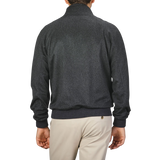 A person wearing a Charcoal Grey Cashmere Zip Blouson by Maurizio Baldassari and light-colored pants is shown from the back against a plain background.