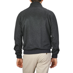 A person wearing a Charcoal Grey Cashmere Zip Blouson by Maurizio Baldassari and light-colored pants is shown from the back against a plain background.