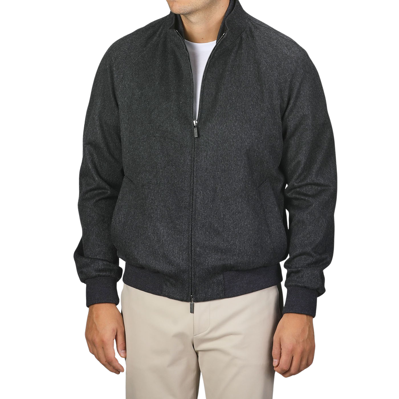 A person is standing against a plain background wearing a Maurizio Baldassari Charcoal Grey Cashmere Zip Blouson, fully zipped with a high collar, paired with beige pants. The person's face is not visible.