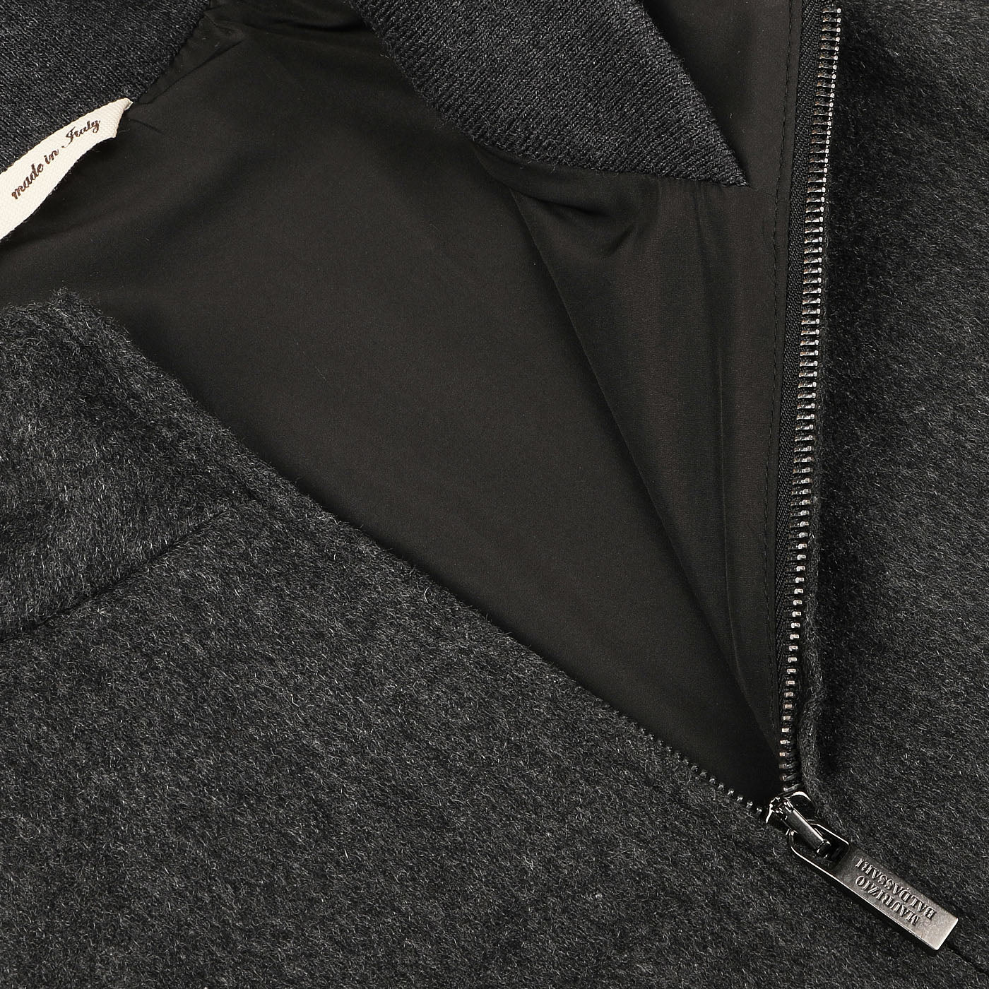 Close-up of a Maurizio Baldassari Charcoal Grey Cashmere Zip Blouson with a visible zipper and a label reading "Made in Italy.