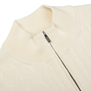 Close-up view of a Maurizio Baldassari Cream Cotton Silk Cable Knit 1/4 Zip Sweater with a zipper detail at the collar.