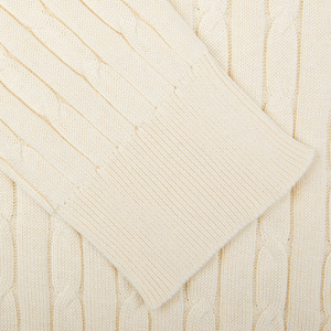 Close-up view of a Maurizio Baldassari cream-colored cotton-silk blend cable knit sweater fabric.