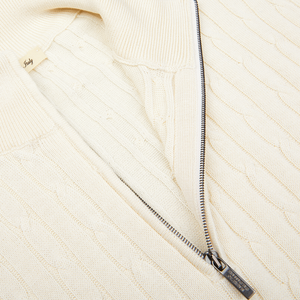 Close-up of a textured cream cotton-silk blend cable knit sweater with a zipper detail by Maurizio Baldassari.