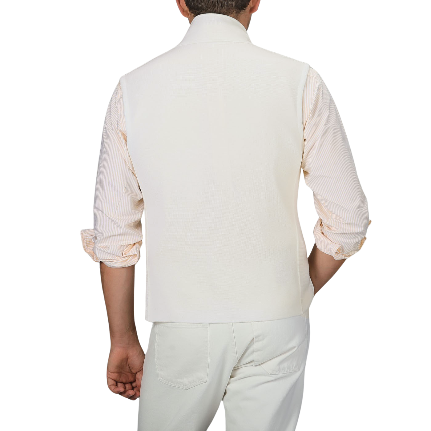 A man is shown from behind wearing a Maurizio Baldassari Cream Milano Stitch Wool Zip Gilet, a light-colored rolled-up sleeve shirt, and cream-colored pants.