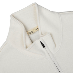 Close-up of the Cream Milano Stitch Wool Zip Gilet featuring a high collar and a zipped front, crafted with care. A beige label inside reads "MAURIZIO BALDASSARI made in Italy," reflecting its premium quality and design expertise.