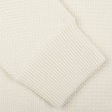 Close-up of a cream-colored Maurizio Baldassari Cream Beige Silk Cotton Knitted Blouson sweater with ribbed cuff detail.