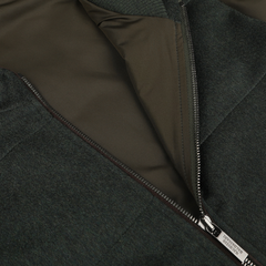 Close-up image of the Dark Green Water Repellent Cashmere Gilet by Maurizio Baldassari, showcasing a half-open metallic zipper that reveals the inner lining. Crafted from 100% cashmere, this piece also features a water-repellent finish for added practicality.