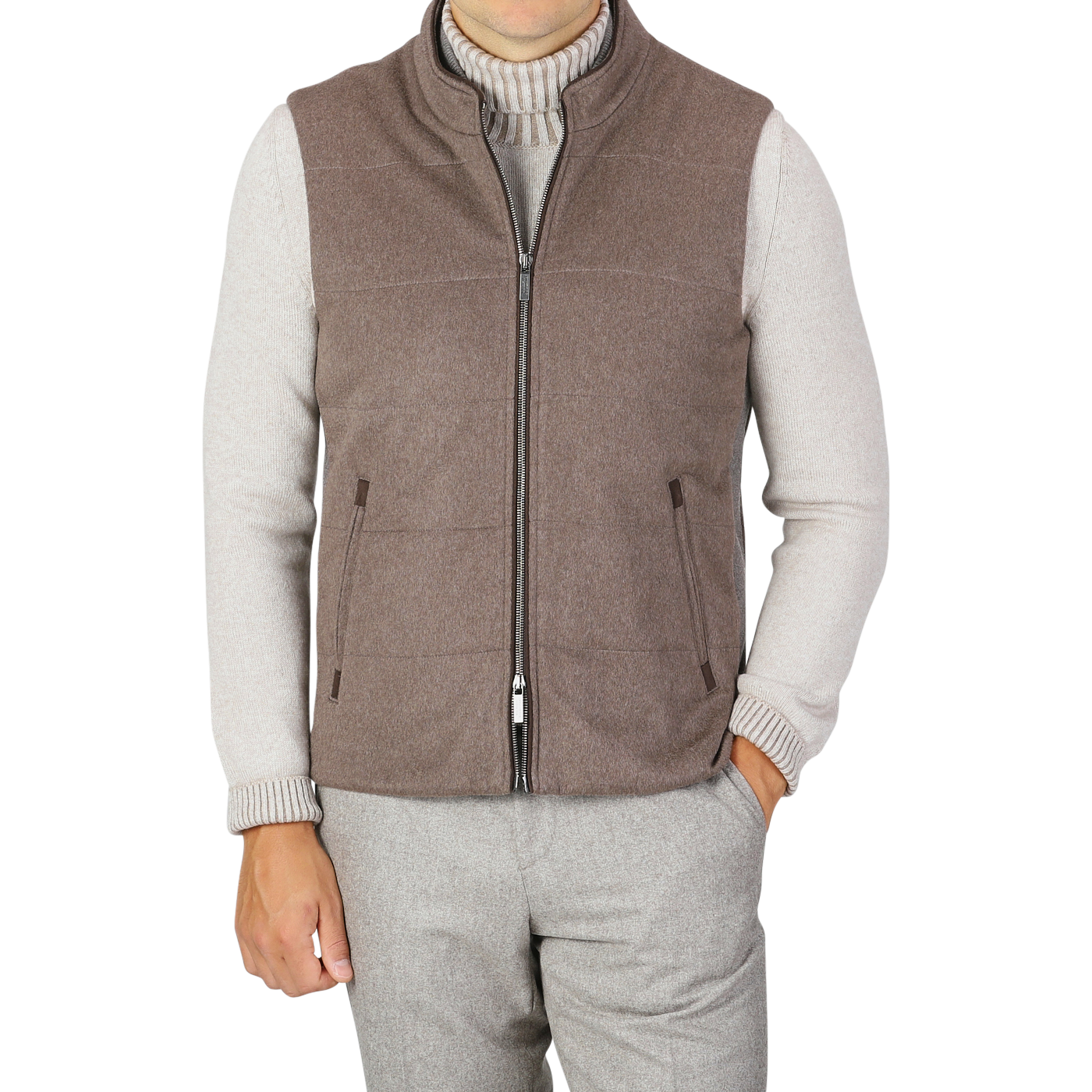 A person dressed in a gray long-sleeve shirt under a sleeveless, zip-up Dark Taupe Water Repellent Cashmere Gilet from Maurizio Baldassari, with their right hand in their pocket. They are also wearing gray trousers. The stylish ensemble features pieces like the water-repellent vest, blending practicality and elegance seamlessly.