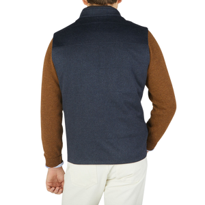 The back view of a man wearing a Maurizio Baldassari Denim Blue Water Repellent Pure Cashmere Gilet.