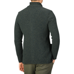 A person is seen from the back, wearing a Green Melange Winter Wool Mouline Swacket by Maurizio Baldassari and olive green pants against a plain background. The outfit features a stylish wool-cotton blend, adding both warmth and sophistication to the look.