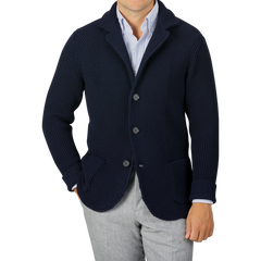 A person wearing a Maurizio Baldassari Navy Blue Zegna Baruffa Wool Brenta Jacket over a white and blue striped shirt and gray trousers, showcasing exceptional craftsmanship. The face is not visible.