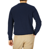 The back view of a man wearing a Maurizio Baldassari Navy Cotton Mouline Crew Neck Sweater and khaki pants.