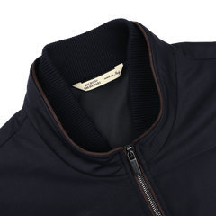 Close-up of the Maurizio Baldassari Navy Merino Wool Thermore Travel Gilet, featuring a front zipper, brown trim, and Thermore insulation. The label inside reads "Made in Italy" with black text on a white background.