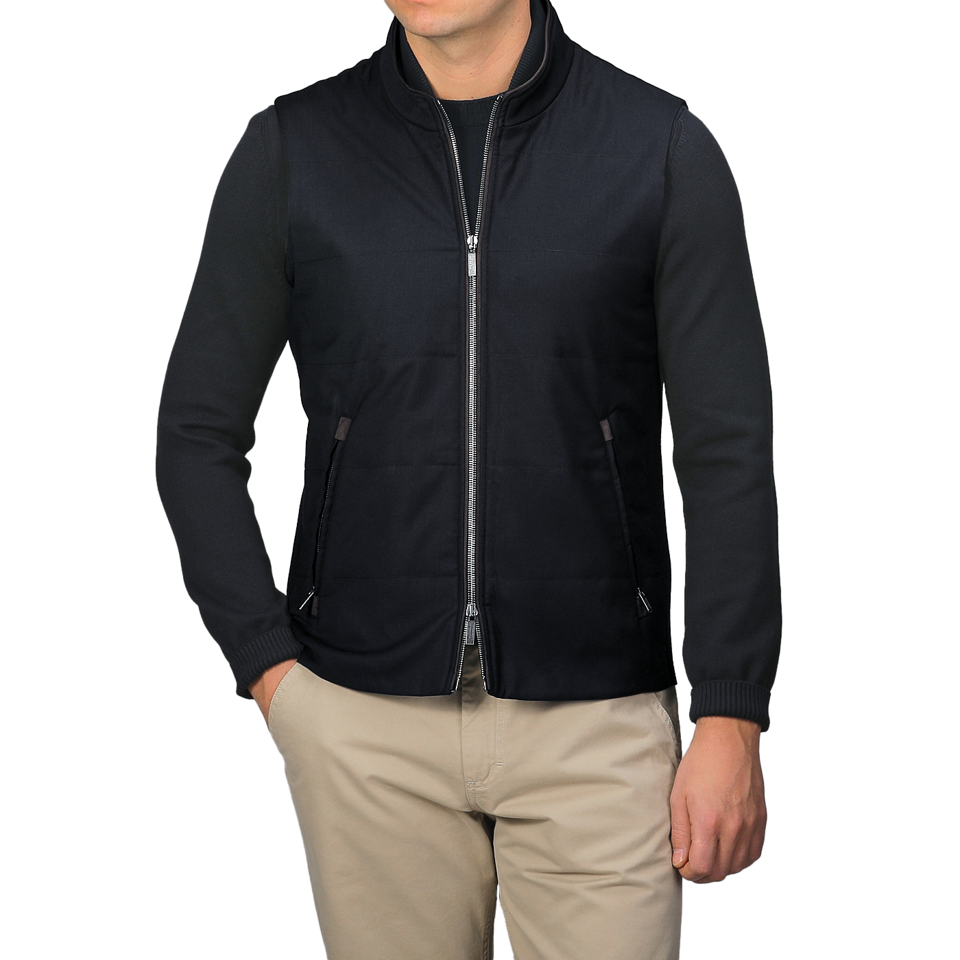 Wearing a Maurizio Baldassari Navy Merino Wool Thermore Travel Gilet over a black long-sleeve shirt and beige pants, an individual stands against a plain background.