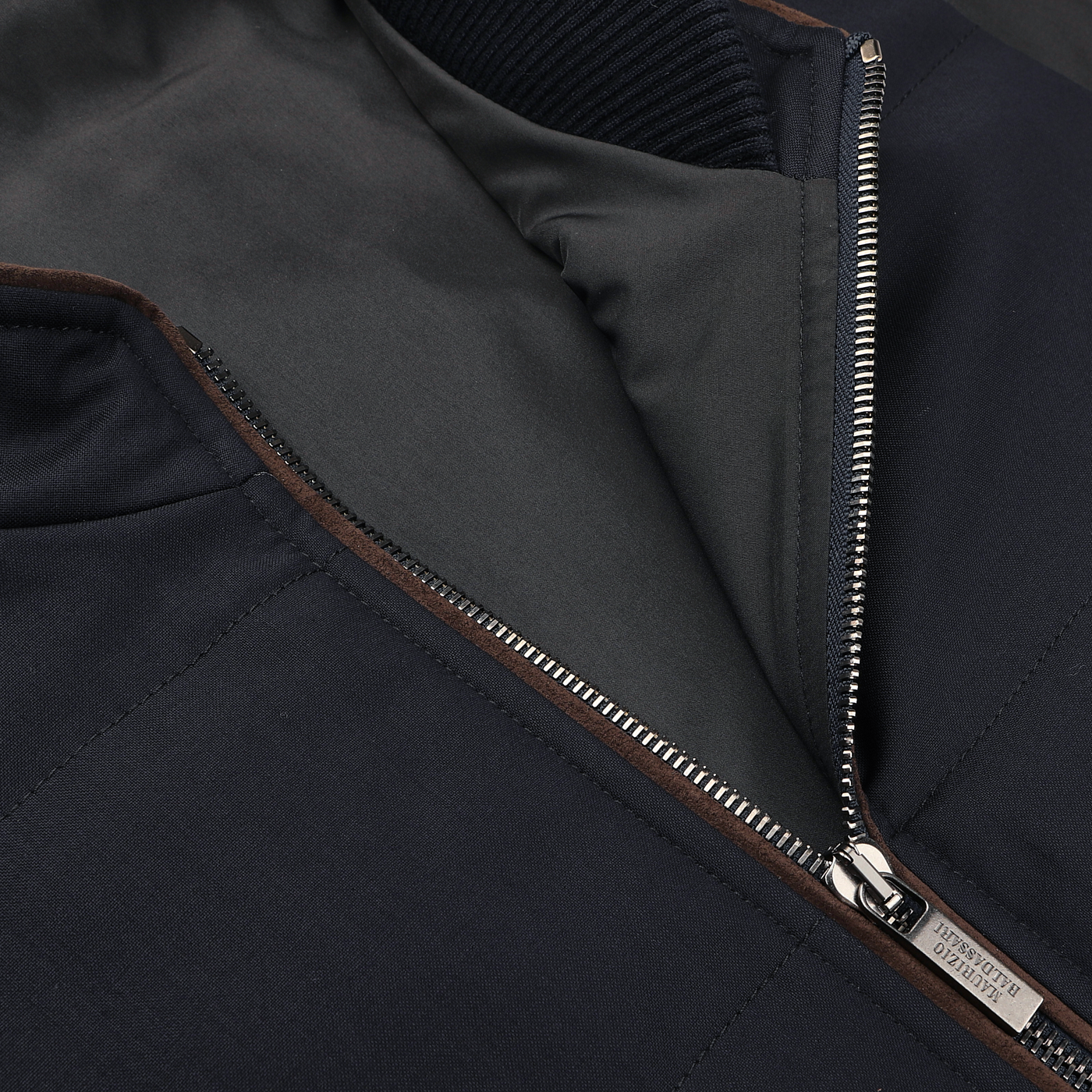 Close-up of a partially unzipped Navy Merino Wool Thermore Travel Gilet by Maurizio Baldassari, showcasing a silver zipper and black inner lining made from water-resistant jersey.