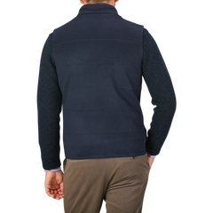 A person is shown from the back wearing a Navy Water Repellent Pure Cashmere Gilet by Maurizio Baldassari over a long-sleeve shirt and brown pants.