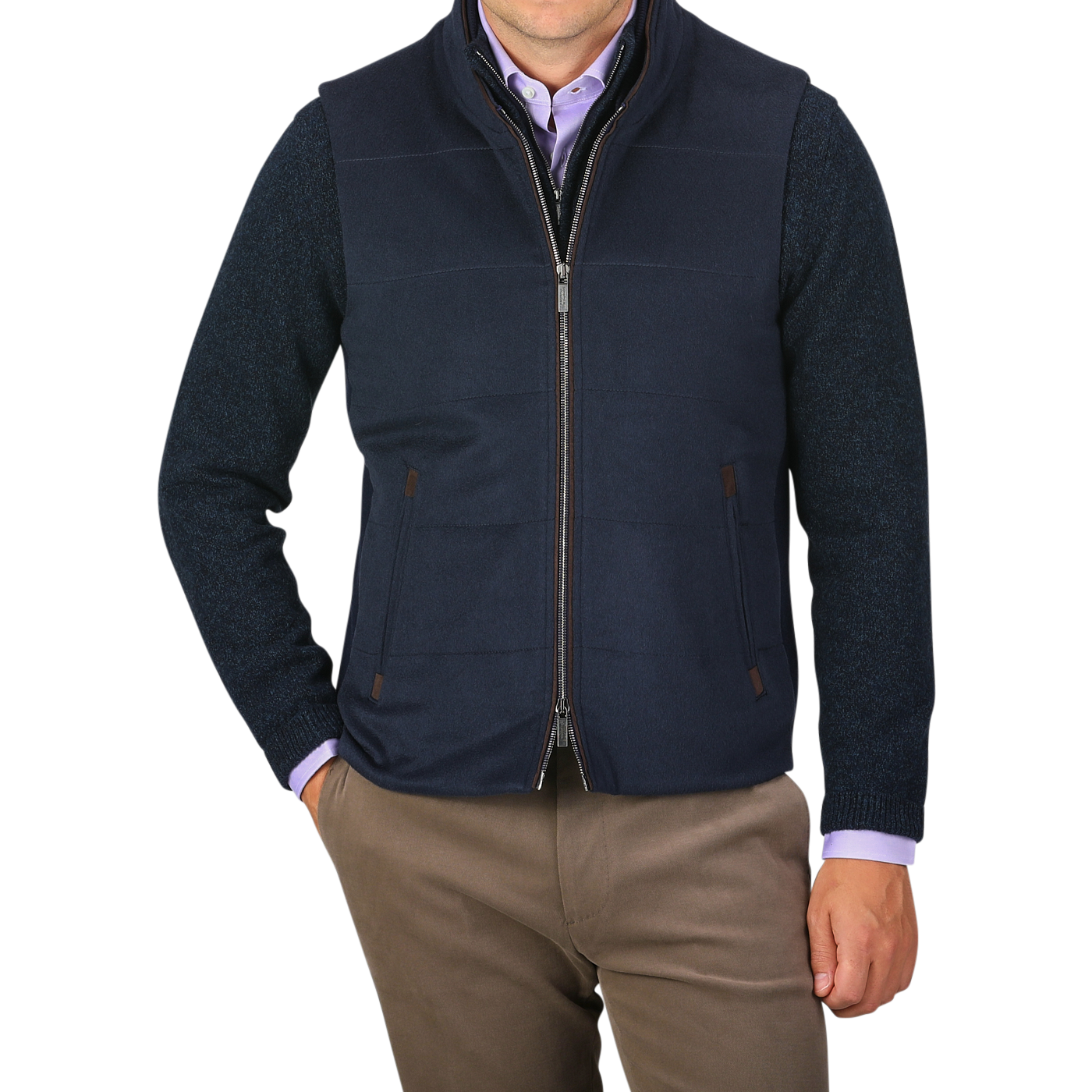 A person wearing a Navy Water Repellent Pure Cashmere Gilet by Maurizio Baldassari over a blue sweater and light purple shirt, with brown pants. The person has their hands in their pockets against a plain background.