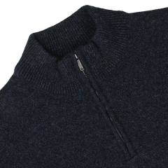 A close-up image of the Maurizio Baldassari Navy Winter Wool Mouline 1/4 Zip Sweater, crafted from soft Tasmanian wool in a navy blue melange, featuring a ribbed collar and partially open zipper.