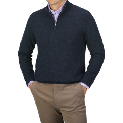 A person wearing a Maurizio Baldassari Navy Winter Wool Mouline 1/4 Zip Sweater over a light purple shirt, paired with light brown pants, stands with hands in pockets against a gray background.