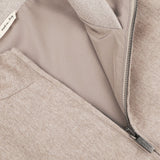 Close-up of an Oatmeal Beige Cashmere Zip Blouson by Maurizio Baldassari with a partially opened zipper and a white tag that reads "made in Italy." The inner lining and zipper details of the jacket are visible, along with the ribbed hems.