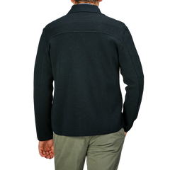 A person wearing a Maurizio Baldassari Petrol Green Milano Knitted Wool Overshirt and light pants is shown from behind against a plain background.